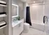 White tiled bathroom with chic black and white decor at Model Tobacco Lofts.