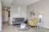 Inviting living room with modern gray sofa, vibrant yellow armchair, artistic wall decor, and a cozy ambiance.