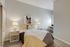 Cozy modern bedroom featuring a stylish bed with colorful bedding, contemporary artwork, and dual side lamps.