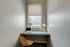 Cozy home office nook with a bright window, sleek laptop on a floating desk, stylish chair, and chic lamp, ideal for productive work hours.