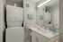 Chic bathroom with convenient in-unit washer and dryer, modern vanity, and elegant decor.