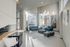 Bright and modern apartment lobby with stylish blue seating, large windows, and contemporary art, offering a welcoming and sophisticated ambiance.