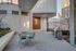Modern outdoor patio with sleek dining set and barbecue grill, perfect for entertaining in an urban setting.