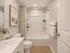 Elegant bathroom featuring a pristine white vanity, modern bathtub, and tasteful decor with beach-themed artwork.