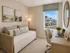 Bright and inviting home office with a stylish daybed, large window showcasing peaceful neighborhood views, and a modern desk setup for productivity.