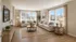 Bright and spacious living room with elegant decor, featuring large windows, cozy sofas, and stylish wooden accents.