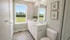 Bright and inviting bathroom with dual sinks, large mirrors, and a picturesque outdoor view.