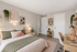 Bright and cozy bedroom with elegant decor, featuring a plush bed, inspiring wall art, and a stylish workspace.