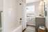 Bright, elegant bathroom with a modern vanity, relaxing tub, and large window providing natural light. Perfect for a serene retreat.