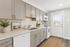 Bright and modern kitchen with sleek gray cabinetry, stainless steel appliances, and abundant natural light.