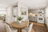 Modern open-floor apartment featuring a bright kitchen with sleek gray cabinets, cozy dining area with a wooden table, and an inviting living room with ample natural light.