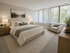 Inviting bedroom with a plush king-size bed, elegant decor, ample natural light, and serene outdoor views through large windows.