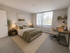 Elegant bedroom featuring a plush bed with green accents, a cozy workspace with natural light, and stylish decor.