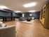 Spacious, stylish game room with a sleek pool table, modern seating area, and elegant wooden flooring.