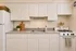 Charming kitchen with sleek white cabinets, modern appliances, and inviting natural accents.