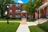 Charming brick apartment building with manicured lawns and inviting entrance, enhancing curb appeal.