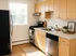 Bright, modern kitchen with sleek black appliances, natural wood cabinets, and stylish decor.