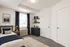 Inviting bedroom with elegant decor, featuring a cozy bed, stylish dark blue curtains, and modern shelving.