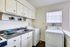 Charming utility area with efficient washer and dryer, accented by bright cabinetry and a modern sink setup.