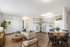 Bright and airy open-plan living space with a modern kitchen, cozy seating area, and elegant dining set, perfect for entertaining.