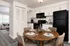 Chic dining area with modern kitchen featuring sleek appliances and a cozy living room in open-plan design.