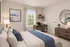 Bright and modern bedroom boasting a cozy workspace, elegant furnishings, and serene decor.