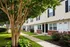 Inviting apartment complex featuring charming exterior with lush greenery and well-maintained pathways leading to multiple entrances.
