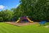 Inviting community playground surrounded by lush greenery, featuring vibrant slides and swings for endless fun.