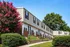 Charming townhouse exterior with vibrant landscaping and inviting pathways, perfect for a cozy suburban lifestyle.