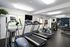 Modern fitness center with state-of-the-art treadmills, elliptical machines, and a mirrored wall, offering a bright and inviting workout space.