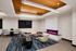 Elegant lounge area featuring modern furniture, vibrant blue carpet, and a sleek fireplace with a pink flame.