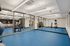 Modern fitness center with sleek blue flooring, exercise equipment, and mirrored walls for an inviting workout experience.