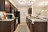 Elegant kitchen with granite countertops, dark wood cabinets, and modern appliances, featuring a cozy dining nook and decorative touches.