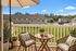 Charming balcony with stylish seating, lush greenery, and scenic neighborhood views, perfect for relaxing outdoors.