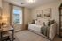 Charming home office with cozy daybed, wooden desk, and soft lighting, perfect for productivity and relaxation.