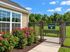 Inviting community dog park with lush green lawn and vibrant flower garden, perfect for outdoor enjoyment.