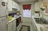 Refrigerator, counters, cabinets, stove, microwave, and sink in a kitchen at Cayce Cove