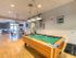 Pool table, ping-pong table in game center with wood-plank style flooring The Landings at Chandler Crossings | MSU Student Housing