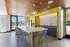 Modern kitchen with sleek design, featuring a large island, vibrant yellow accents, and stylish pendant lighting.