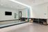 Chic and inviting fitness room with a wall-mounted TV, large mirrors, and neatly organized yoga mats and equipment for a wellness-focused lifestyle.