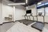Modern fitness room with sleek treadmills, bright lighting, and large windows offering a fresh workout experience.