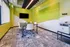 Modern conference room with vibrant green walls, sleek furniture, and ample natural light for an inspiring workspace.
