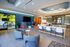 Modern open-concept lounge area with vibrant colors, sleek furniture, and a spacious meeting room.