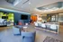 Chic communal lounge with modern seating, vibrant wall accents, and a stylish meeting room, offering a perfect blend of comfort and functionality.