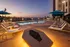 Luxurious rooftop pool with elegant loungers and sunset views, perfect for relaxation and unwinding.
