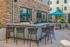 Chic outdoor patio area with modern bar seating and sleek stone wall, perfect for social gatherings.