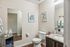 Elegant modern bathroom featuring sleek granite countertop, stylish artwork, and plush towels.