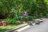 Inviting entrance to The Reserve at Athens surrounded by lush greenery and vibrant flowers.