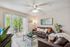 Bright and inviting living room with plush sofas, elegant decor, and a serene garden view through sliding glass doors.