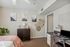 Charming bedroom with modern decor, featuring a stylish dresser, artistic wall hangings, cozy pink blanket, and a functional workspace with a laptop and lamp.